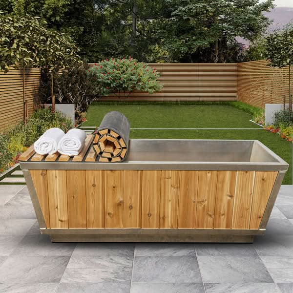 Dundalk Glacier Red Cedar Plunge Tub with stainless interior and towels in a backyard