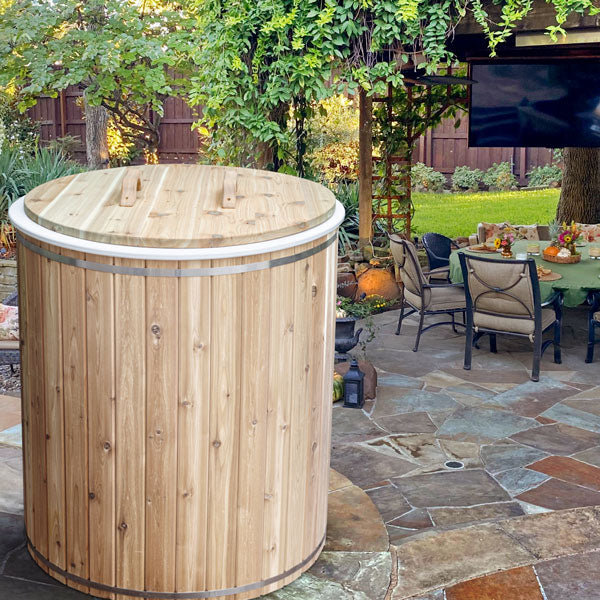 Dundalk Baltic Cedar Cold Plunge barrel with cedar lid closed on a backyard patio