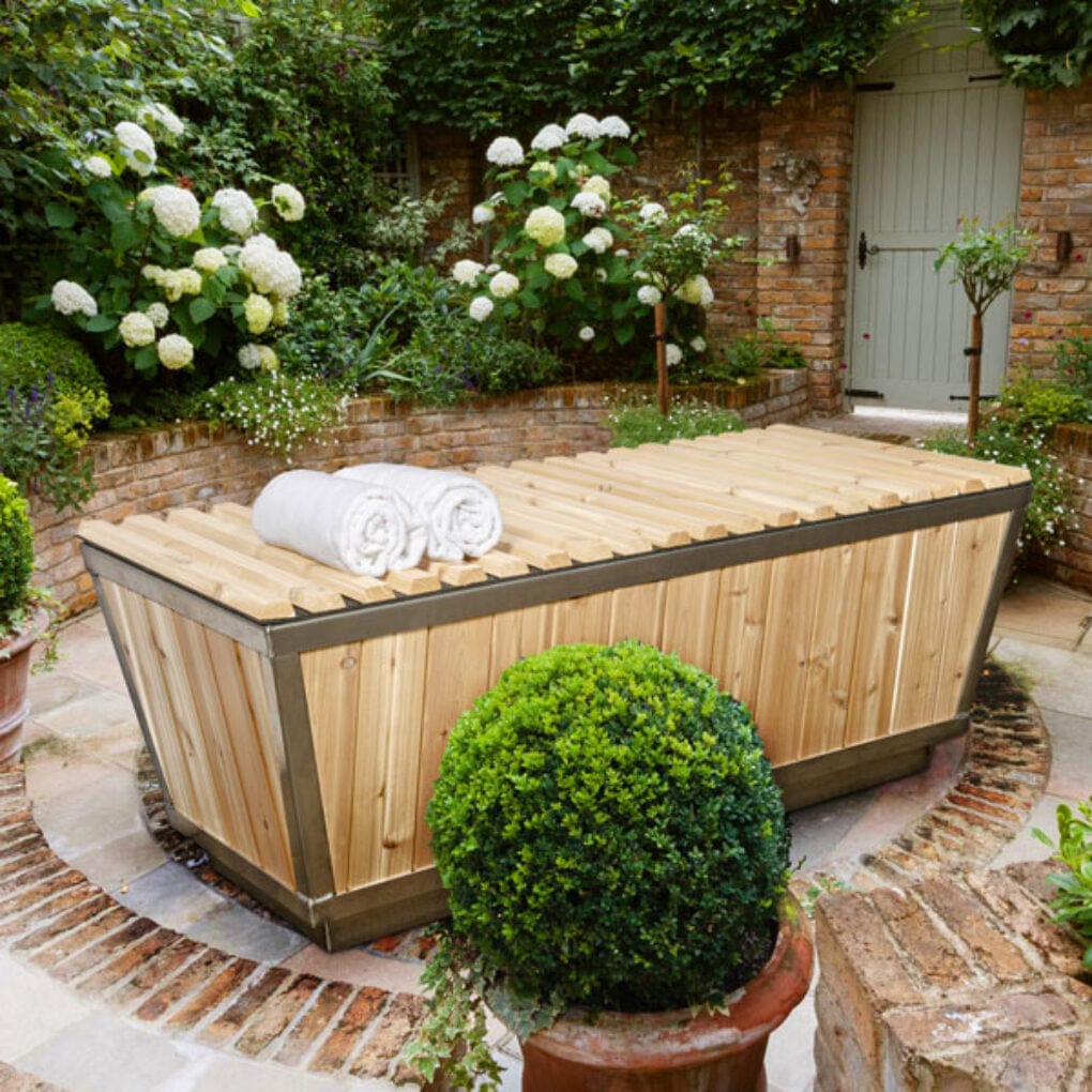 Dundalk Polar Plunge Tub with cedar roll-up lid closed in a garden patio setting